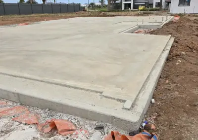 Overview of a completed concrete foundation with utility installations visible.