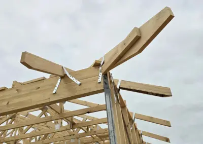 Installation of horizontal timber beams for roof support at a Queensland construction site.